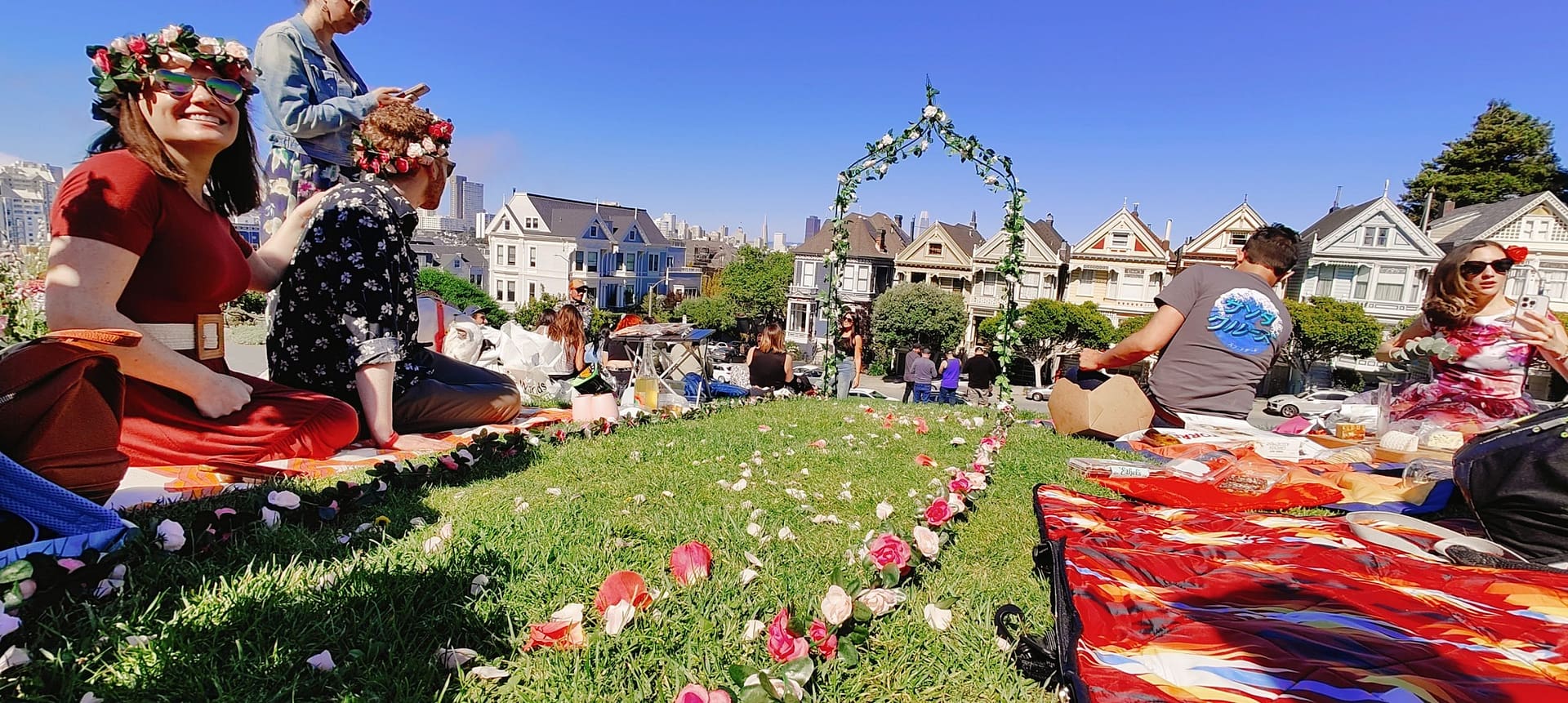 A flower pedal strewn fashion runway leading to a flower arch.